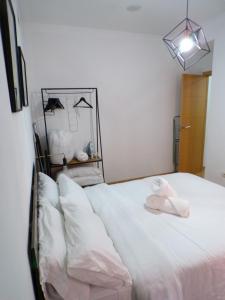 a white bed with a hat on top of it at Rental in the center of Granada 1B in Granada