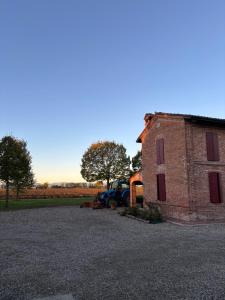 a brick building with cars parked in a parking lot at Agriturismo Varana in Zibello