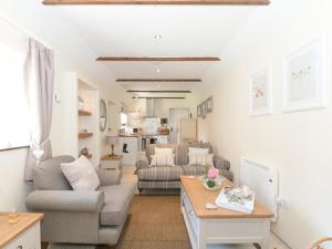 ein Wohnzimmer mit Sofa und Tisch in der Unterkunft Cherry Blossom in Thornton Dale