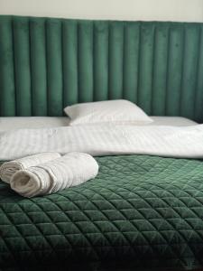 a bed with two towels sitting on top of it at Stary Zajazd in Zielona Góra