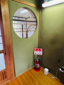 橋本市にあるゲストハウス輪の緑の壁に丸い鏡がある部屋