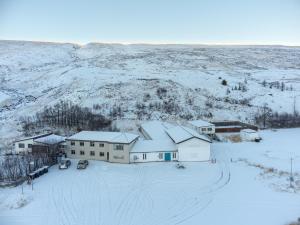 an aerial view of a house in the snow at Studlagil INN Hostel in Skjöldólfsstaðir