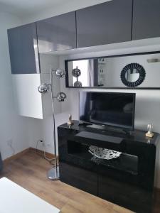 a living room with a television and a black table at Foux d'Allos, studio de 27m2 en centre-ville, plein sud avec terrasse in La Foux d'Allos