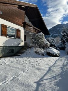 a house with snow on the ground in front of it at Ferienhaus Kaiser Lothar in Reutte