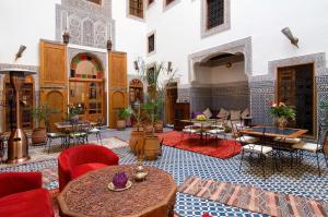 a room with tables and chairs in a building at Riad La Clé De Fès in Fez