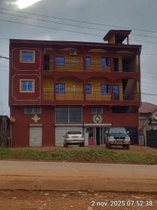 a red building with two cars parked in front of it at Euro Modern Studios Nkoabang-Yaounde in Yaoundé