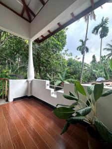 a living room with a wooden floor and a plant at Yasiru Villa in Weligama