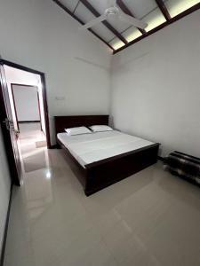 a bedroom with a bed in the corner of a room at Yasiru Villa in Weligama