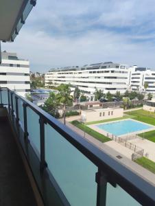 a balcony with a view of a pool and buildings at Los Alamos Breeze - Modern Beach Apartment in Torremolinos