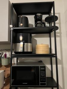 een zwarte plank met een magnetron erop bij Casa Wechi in Willemstad