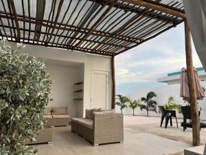 een patio met een bank, stoelen en een tafel bij Casa Wechi in Willemstad