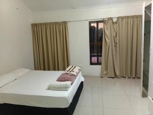 ein weißes Schlafzimmer mit einem Bett und einem Fenster in der Unterkunft Large 4 Bedroom 7 Bed Villa in Sonaisali Rd, Nadi in Nadi