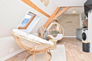 a living room with a swing chair and a kitchen at NOUVEAU BOHEME STUDIO - Netflix & Clim - Centre Ville Transports - Idéal PRO ou COUPLE - Cosy & Confort - NEUF & OFFRE SPÉCIALE in Saint-Omer
