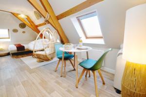 a room with a table and chairs and a bed at NOUVEAU BOHEME STUDIO - Netflix & Clim - Centre Ville Transports - Idéal PRO ou COUPLE - Cosy & Confort - NEUF & OFFRE SPÉCIALE in Saint-Omer +3 photos