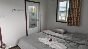a bedroom with a bed with a towel on it at Koh Libong Maldives Homestay in Ban Hua Phrong +8 photos