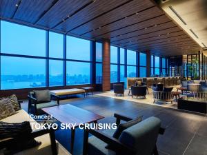 a lobby with chairs and tables and glass windows at Mitsui Garden Hotel Toyosu Premier - Tokyo in Tokyo