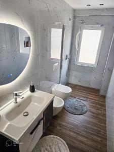 a white bathroom with a sink and a toilet at ALLO Apartments in Durrës +52 photos