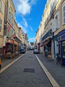an empty city street with buildings and cars on it at Petit Studio quartier Cathédrale in Chartres