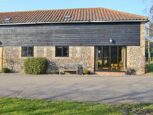 a brick house with a bench in front of it at The Cart Lodge-E3568 in Uggeshall +6 photos