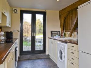 a kitchen with a washer and dryer at The Cart Lodge-E3568 in Uggeshall