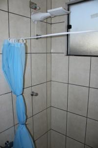 a shower with a blue shower curtain in a bathroom at Studio11 near Drogasil in Ourinhos