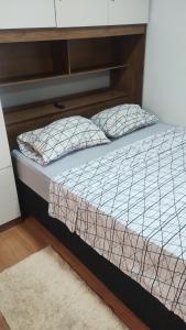 a bed with two pillows on it in a room at Studio11 near Drogasil in Ourinhos