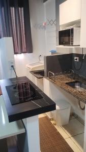 a kitchen with a black counter top and a sink at Studio11 near Drogasil in Ourinhos