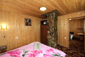 a bedroom with a bed with pink flowers on it at Еко-садиба "Під ліском" in Yablunytsya