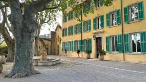 a tree in front of a building with a statue at Appartement mignon calme douillet ascenseur clim étage élevé proche parking et toutes commodités au coeur du Toulon historique in Toulon