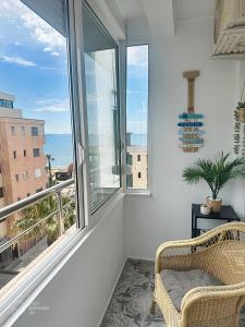a room with a chair and a window with a view at ALLO Apartments in Durrës