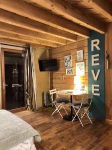 a bedroom with a bed and a table and chairs at Brindepaille in Vallon-Pont-dʼArc