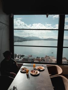 a man sitting at a table with two plates of food at Toer Hotel & SPA in Sarandë