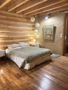 a bedroom with a bed in a wooden wall at Brindepaille in Vallon-Pont-dʼArc