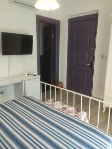 a bedroom with a bed and a flat screen tv at noonbir Alaçatı otel in Alacati +3 photos