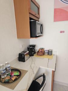 a kitchen with a counter top with a microwave at Suite Serene At Phoenix Park Village 1 in Portmore