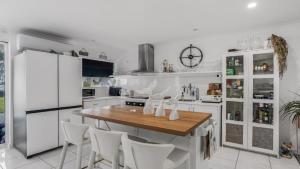 a kitchen with a wooden table and white appliances at The Luxe Waterfront in Sandstone Point