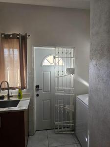 a bathroom with a sink and a white door at Suite Serene At Phoenix Park Village 1 in Portmore