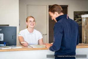 a man and a woman standing at a counter at Camping Loodsmansduin in Den Hoorn +39 photos