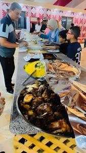 a group of people standing around a long table with food at Desert Front camp in Aqaba