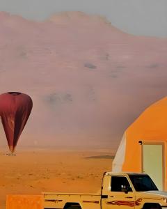 a truck parked next to a tent and a hot air balloon at Desert Front camp in Aqaba
