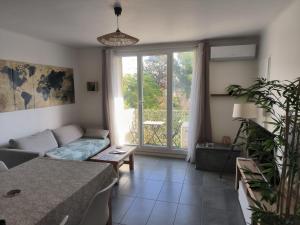 un salon avec un canapé et une grande fenêtre dans l'établissement Les Tamaris, à Arles