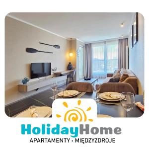米兹多洛杰HolidayHomePL Bel Mare 317e z balkonem的客厅里有一张沙发、一张桌子和几把椅子