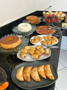 a table with plates of pastries and other food at Pousada Flor de Ipê - Arraial d'Ajuda - a 100m da Rua do Mucugê - principal Rua da cidade in Arraial d'Ajuda +40 photos