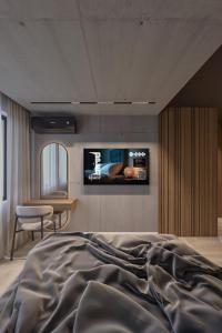 a bedroom with a bed and a tv on the wall at Open Space in Niš +35 photos