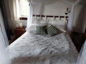 a white bed with two pillows in a bedroom at Casa Cuculo - Rustico mit traumhaftem Meerblick in Scansano