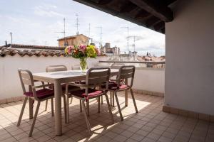 a table and chairs on a balcony with a vase of flowers at SWEETHOME ARENA VIEW - con parcheggio in Verona