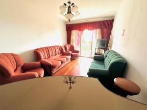 een woonkamer met banken en een tv bij Lido Funchal in Funchal