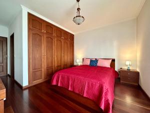 een slaapkamer met een bed met een rode sprei bij Lido Funchal in Funchal