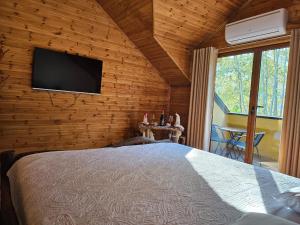 a bedroom with a bed and a flat screen tv at Bujtina Guri Hanit in Ferr-Shkopet