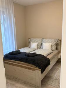 a bed with two pillows on it in a room at HIGHWAY Apartman in Győr